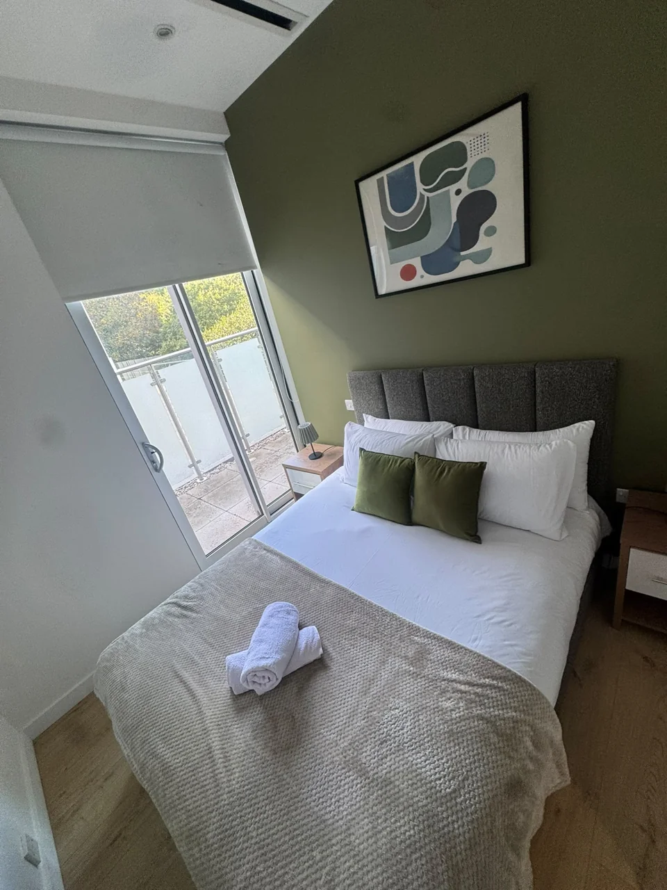 Brentford bedroom after the guest changeover, with remade bedding and folded towels